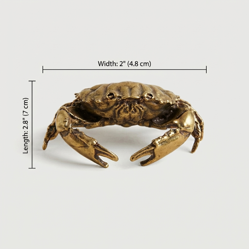Bronze crab figurine with measurements on a white background