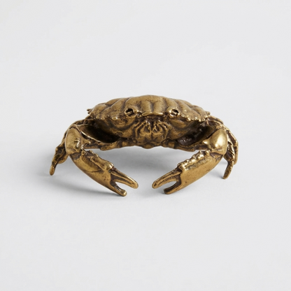 Bronze crab sculpture on a light gray background
