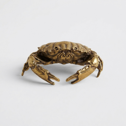 Bronze crab sculpture on a light gray background