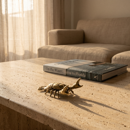 Brass crayfish figurine on wooden bedside table with book
