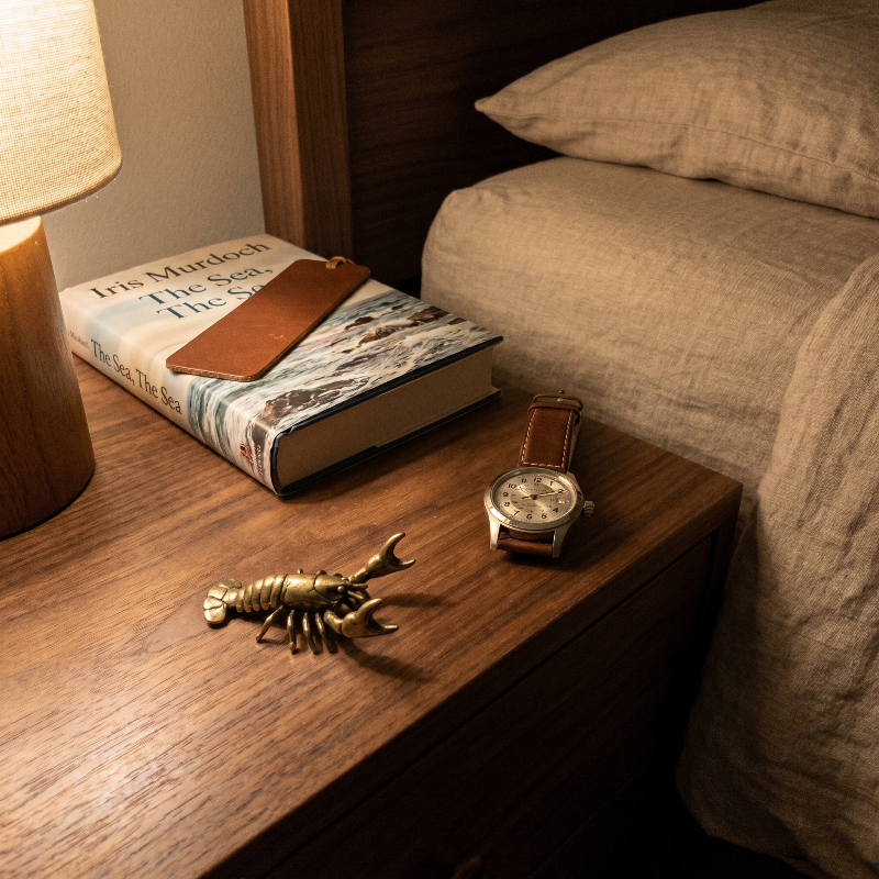 Brass crayfish figurine on bed beside tray and pillow