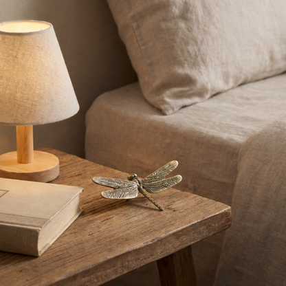 Brass dragonfly figurine on bedside table with lamp