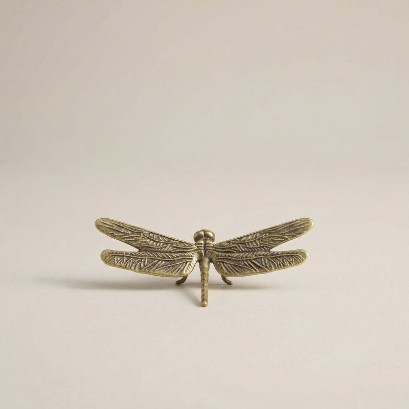 Brass dragonfly sculpture with a warm metallic finish, shown as a decorative accent