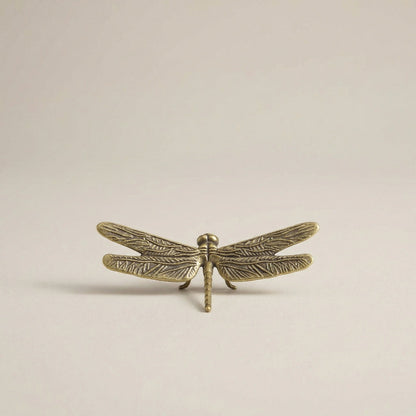 Brass dragonfly sculpture with a warm metallic finish, shown as a decorative accent