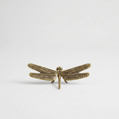 Brass dragonfly figurine on white background