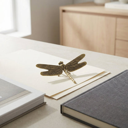 Bronze dragonfly figurine on a stack of books with a blurred background