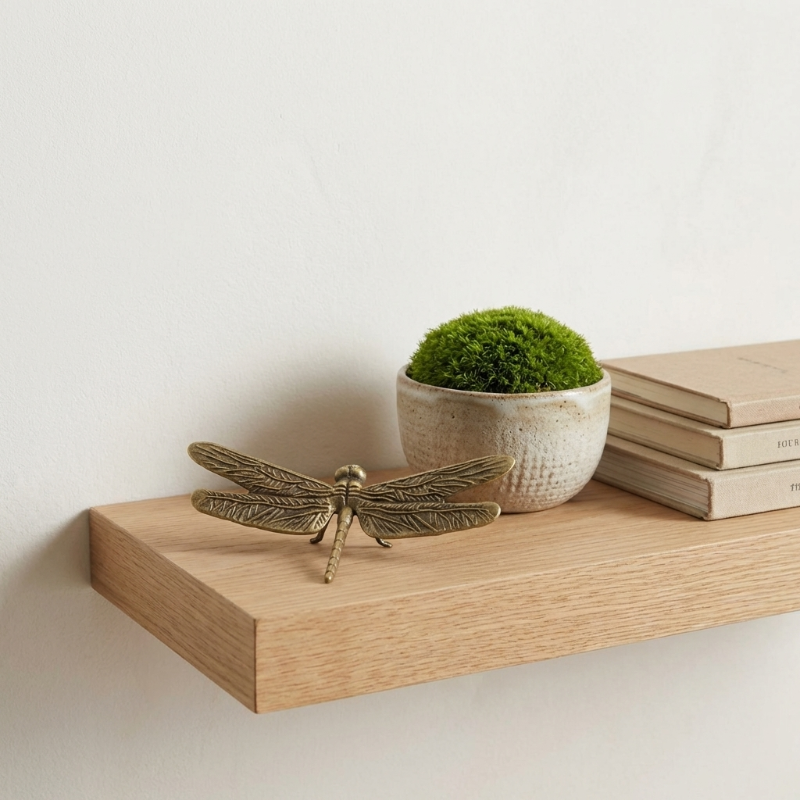 Brass dragonfly figurine on wooden tray with decorative moss