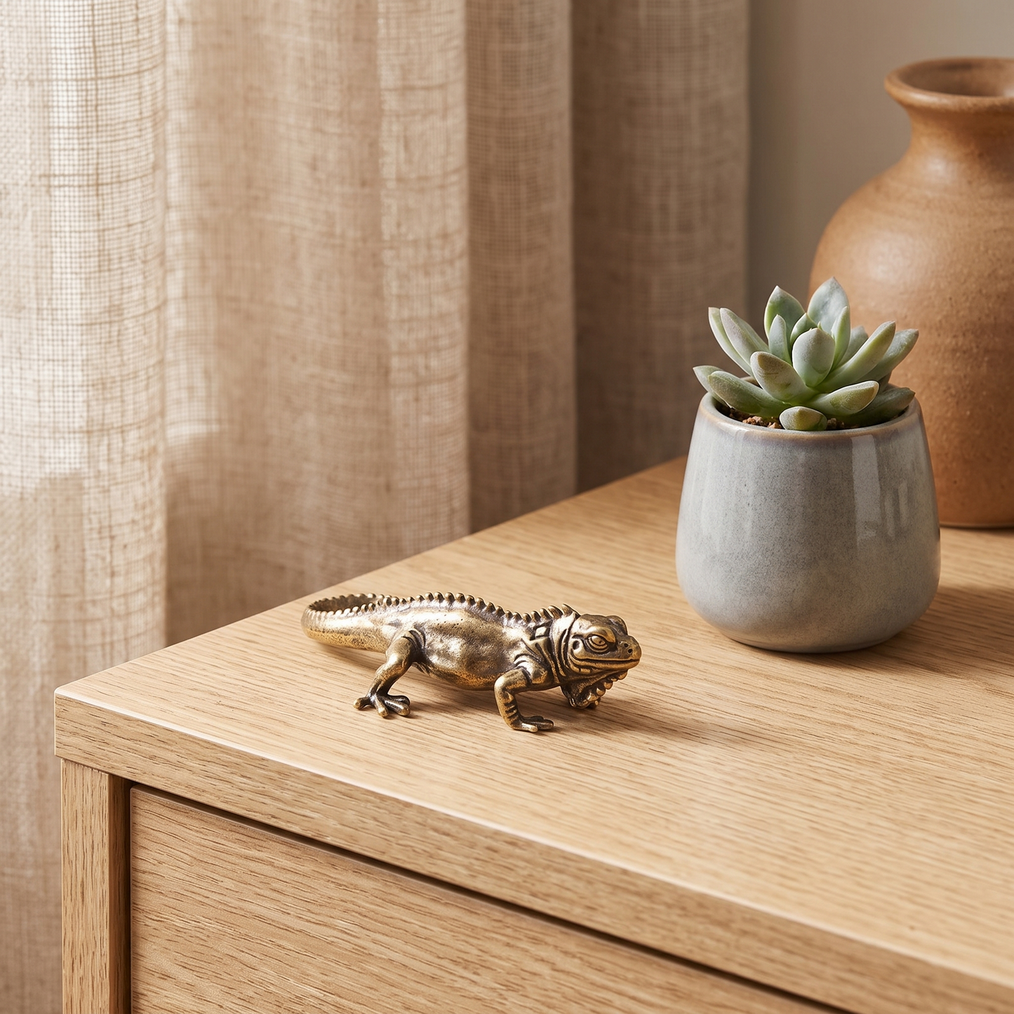 Brass reptile figurine on a side table beside a succulent