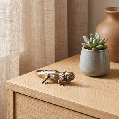 Brass reptile figurine on a side table beside a succulent