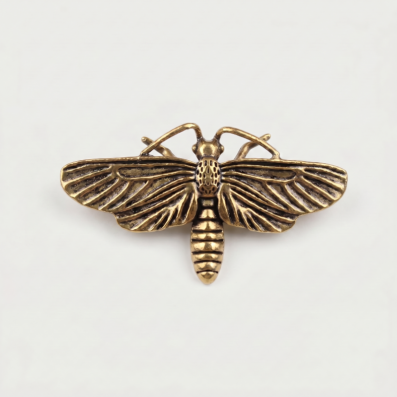 Brass moth sculpture on white background