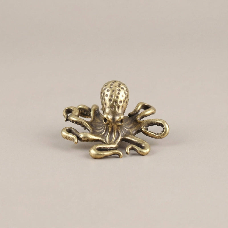 Gold octopus decorative item on a beige background