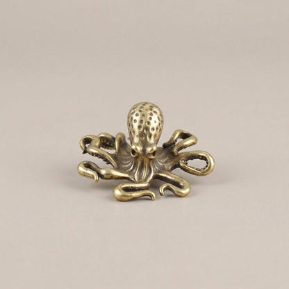 Gold octopus decorative item on a beige background