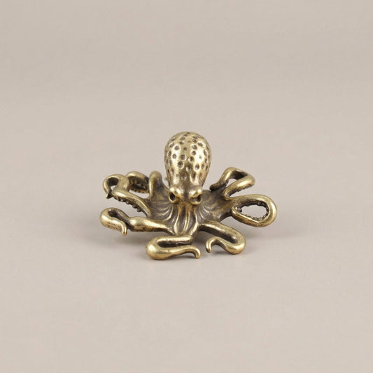 Gold octopus decorative item on a beige background