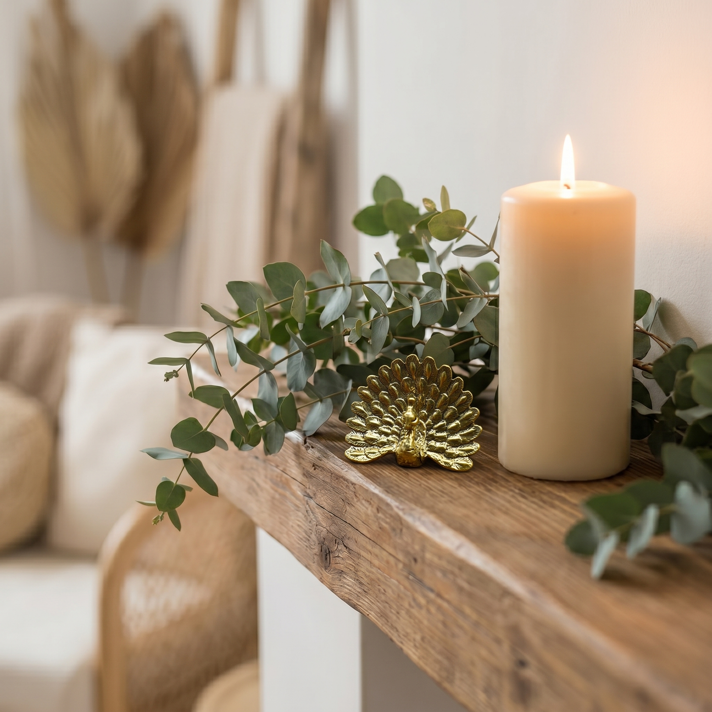 Brass peacock figurine Style D on a fireplace mantel beside eucalyptus greenery