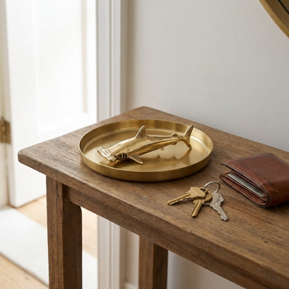 Brass hammerhead shark figurine on wooden side table with tray