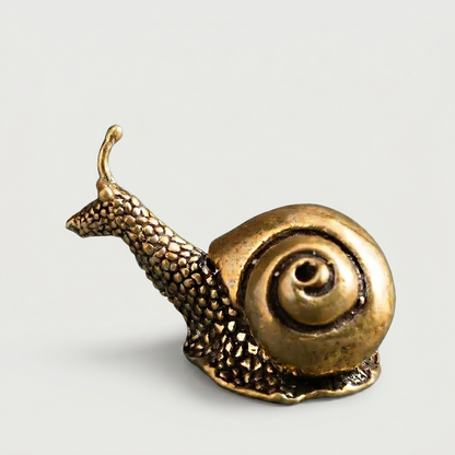 Brass snail figurine on white background facing right