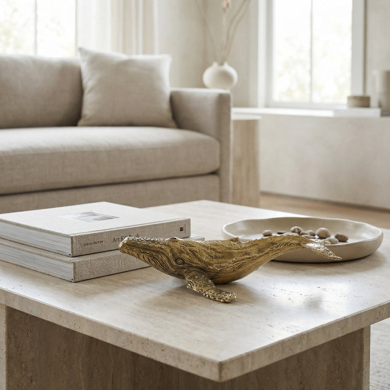 Coffee table with brass whale sculpture in a living room setting