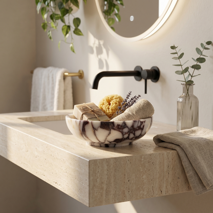 Calacatta marble bowl on bathroom counter beside sink and folded towel