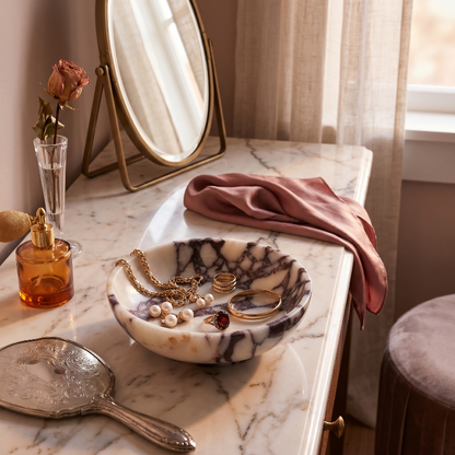 Calacatta marble bowl on bathroom vanity beside mirror and perfume bottle