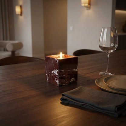 Candle and wine glass on a wooden table in a dimly lit room