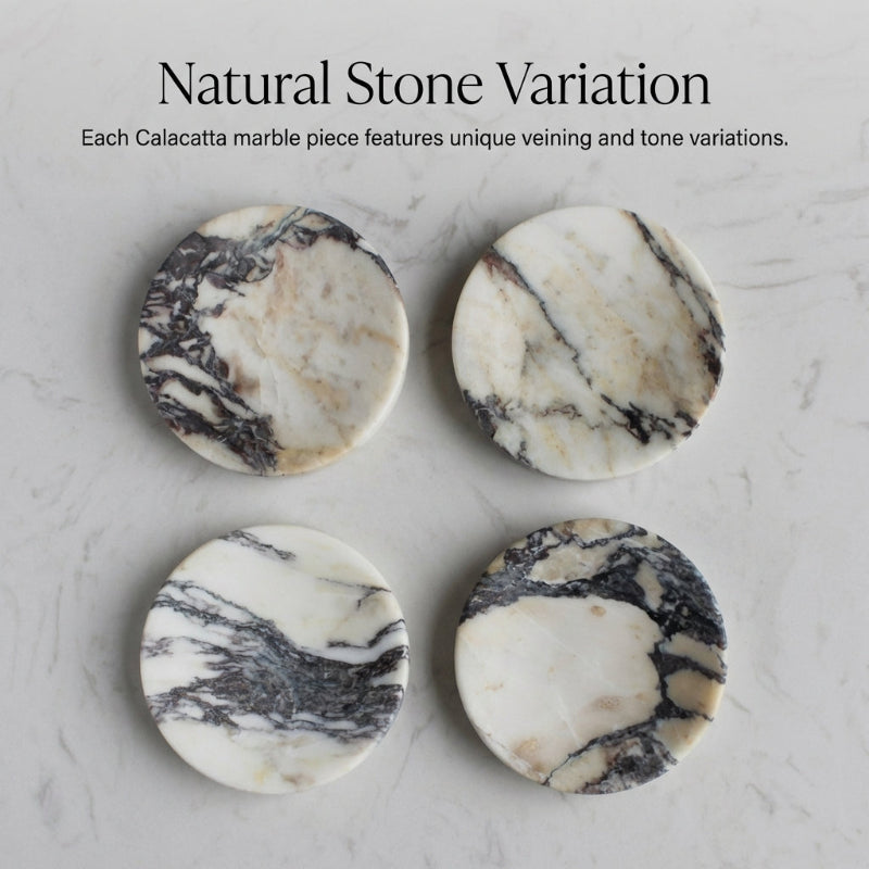 Four marble coasters with natural variations on a marble surface.