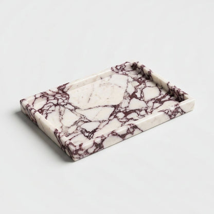 Empty white marble tray with burgundy veining and a low straight rim on a plain light grey backdrop