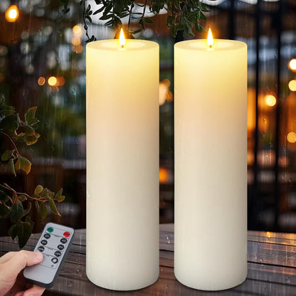 Two tall, ivory LED pillar candles with glowing faux flames sit on a wet wooden table at night while a hand holds a remote control in the foreground.