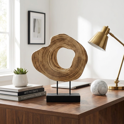 Carved wood abstract sculpture on a desk with a lamp and books, Kiyo Home