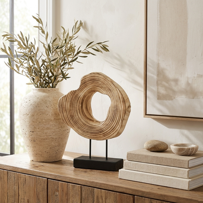 Carved wood abstract sculpture on a sideboard with a vase and olive branch, Kiyo Home