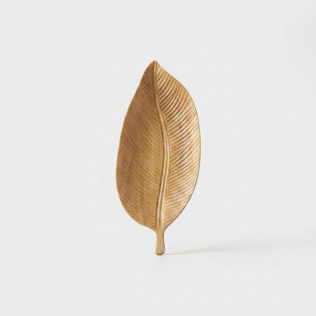 Light wood Carved Leaf Serving Tray standing upright, hero shot on a clean off-white background