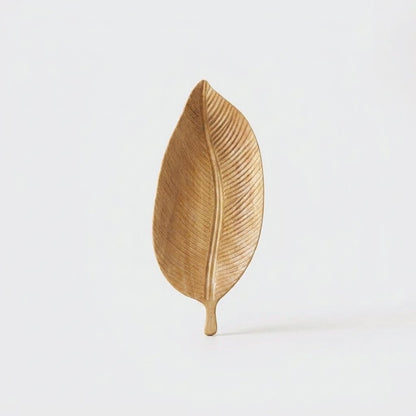 Light wood Carved Leaf Serving Tray standing upright, hero shot on a clean off-white background