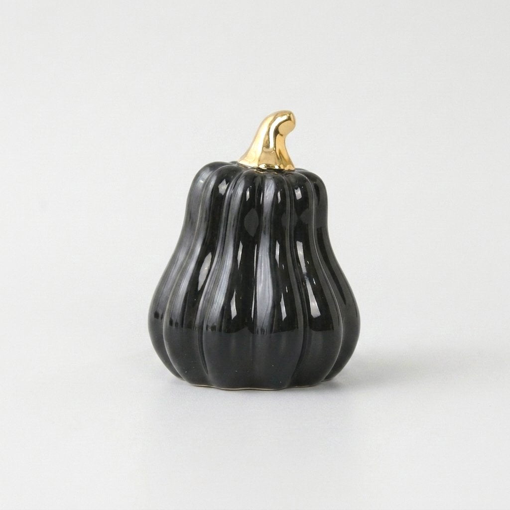 Black ceramic gourd with a gold stem on a white background