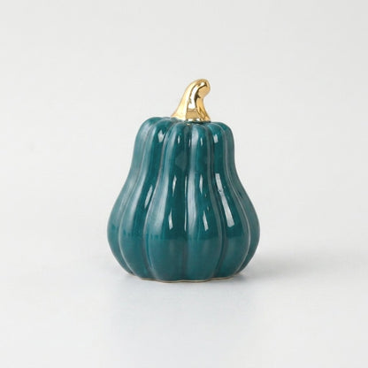Teal-blue ceramic gourd with a gold stem on a white background