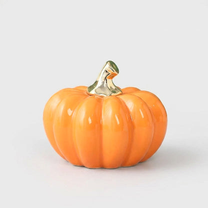 Large orange ceramic pumpkin with a gold stem on a white background