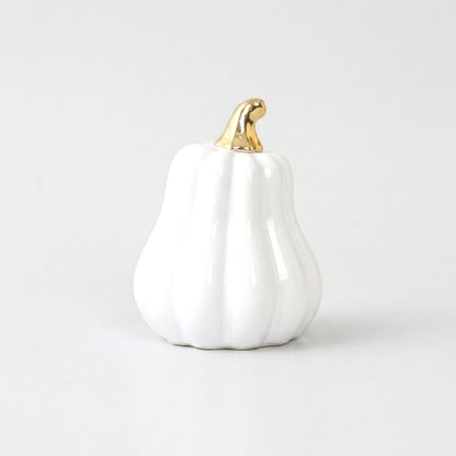 White ceramic gourd with a gold stem on a white background