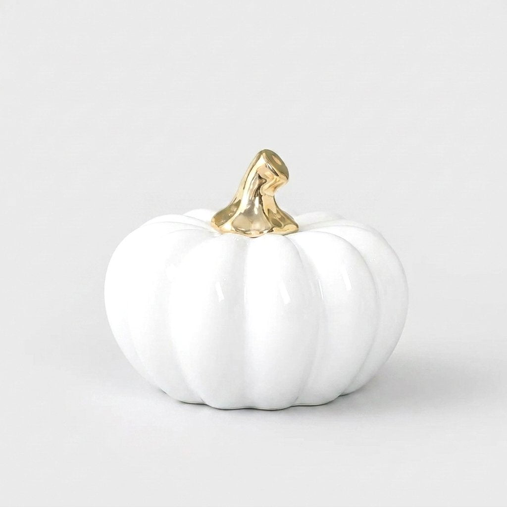 White ceramic pumpkin with a gold stem on a white background, alternate angle