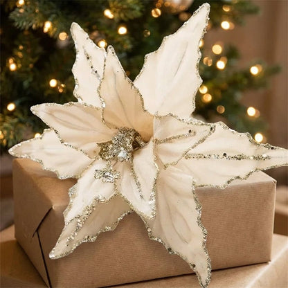 White poinsettia flower with gold glitter edges on a wrapped gift box
