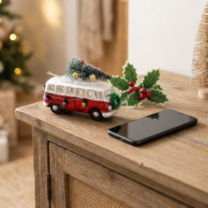 Bus ornament with holly sprig on console table, shown near phone for scale