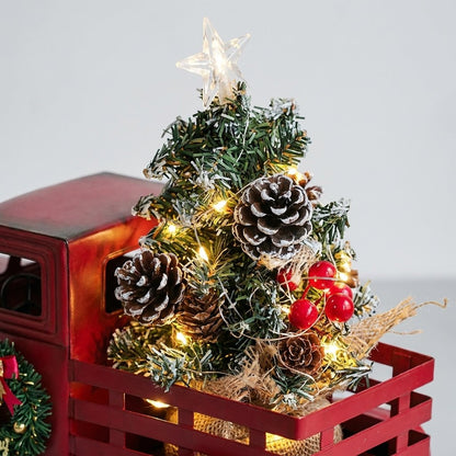 Close-up of lit pine tree topper with pinecones and berries in truck bed