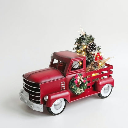 Red metal Christmas truck ornament with lit tree and wreath