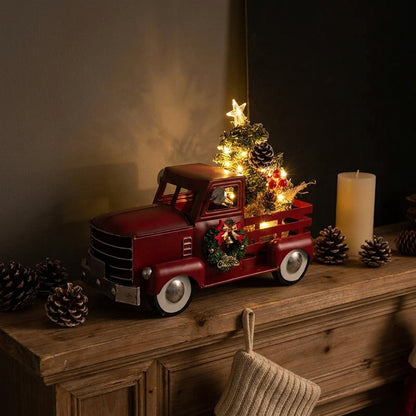 Christmas truck ornament on mantel with pinecones, candle, and stocking