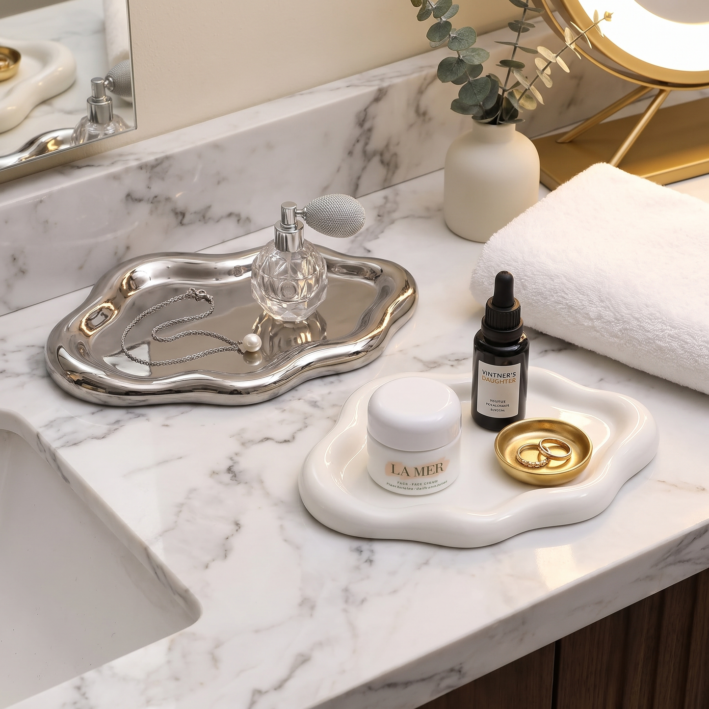 Silver cloud jewelry tray on a marble bathroom counter holding jewelry