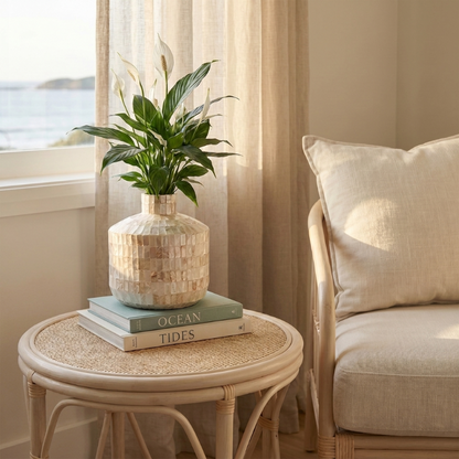 Coastal shell mosaic vase on side table beside armchair
