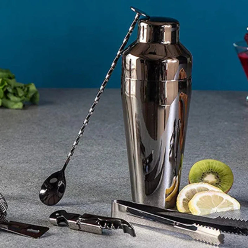 Black stainless steel cocktail shaker styled with fruit on a countertop.