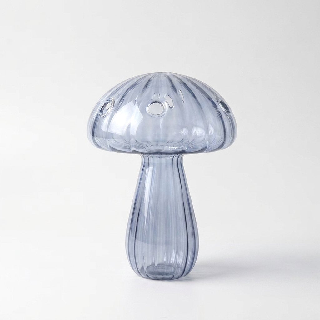 Empty Blue glass mushroom vase on a plain white studio background