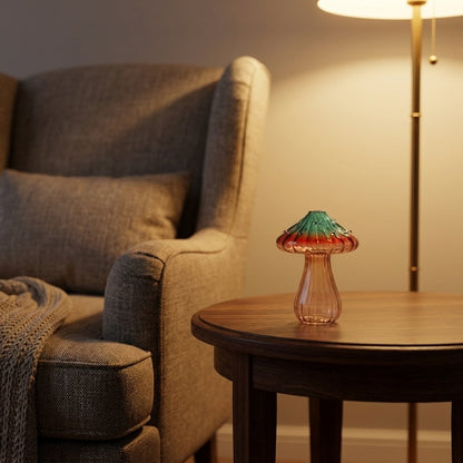 Sunset glass mushroom vase on a round wooden side table beside an armchair and a lit floor lamp, in warm evening light
