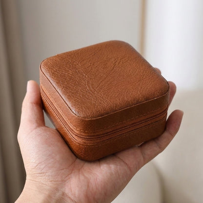 Brown jewelry organizer case held in a hand