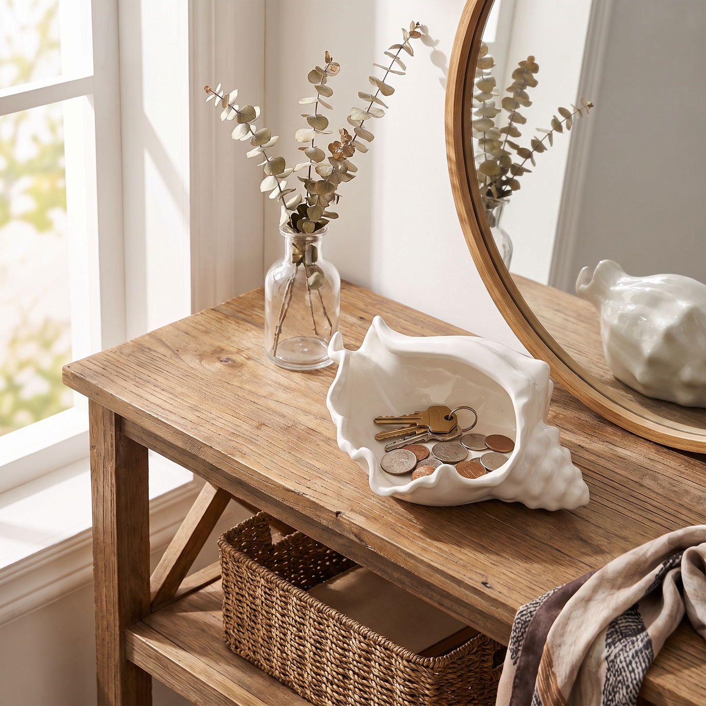 White ceramic conch shell vessel on an entryway console holding keys and coins, Kiyo Home