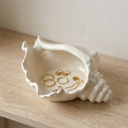 White ceramic conch shell vessel holding gold rings and earrings as a jewelry dish, Kiyo Home
