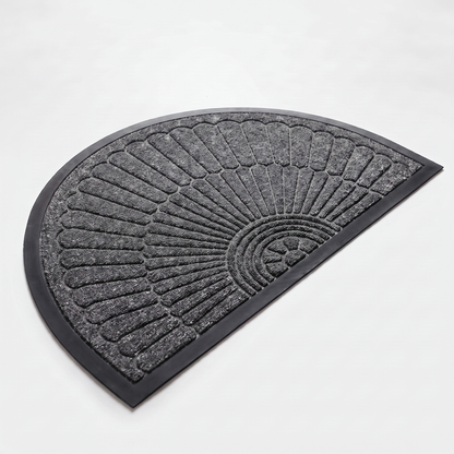 Dark grey crescent half-moon door mat with embossed sunburst design and black rubber border on a clean off-white background